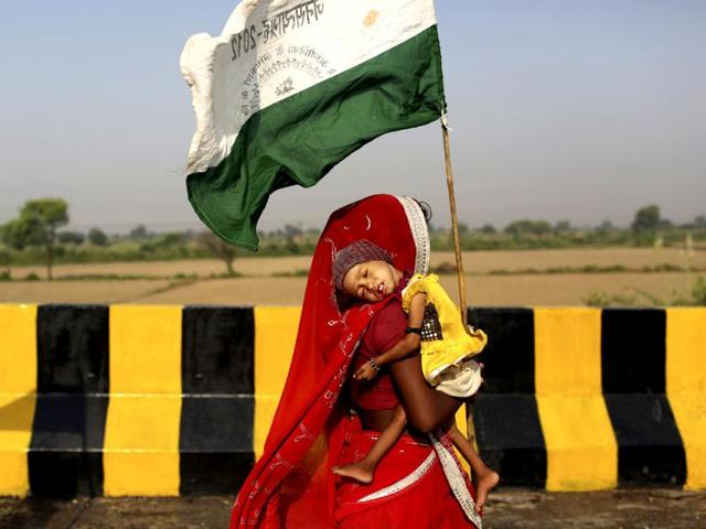 Landless farmer woman carries her child and marches during the "Jan Satyagraha," near Agra. The protesters from nearly a dozen states set out on a 320-kilometer (200-mile) march from Gwalior nine days ago under the banner of 'Ekta Parishad'. AP/Kevin Frayer