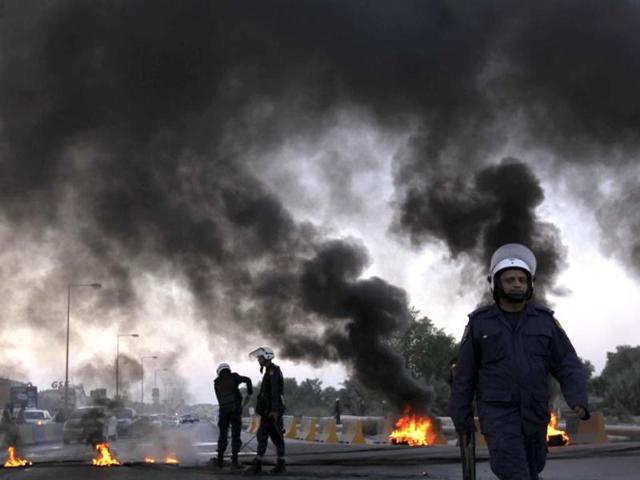 Riot police extinguish burning tires set by Bahraini anti-government protesters, unseen, near oil pipelines that connect to neighboUring Saudi Arabia along a highway in Buri, Bahrain. AP photo