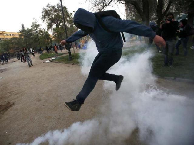 A student protester jumps to avoid a tear gas canister during a protest against the government to demand changes in the public state education in Santiago. Reuters photo