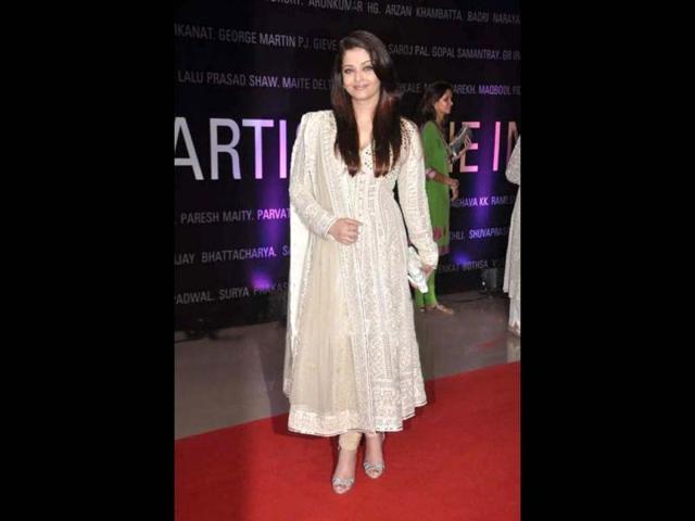 Aishwarya Rai Bachchan stuns in a beige Anarkali suit as she poses a subtle smile at the event.