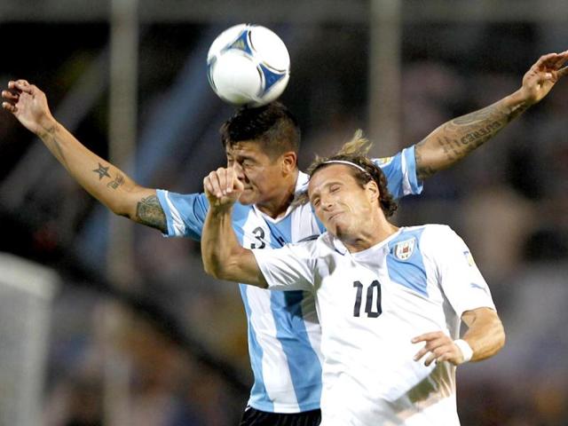 Diego Forlan (R) of Uruguay battles for the ball with Marcos Rojo of Argentina during their 2014 World Cup qualifying soccer match in Mendoza. Reuters photo