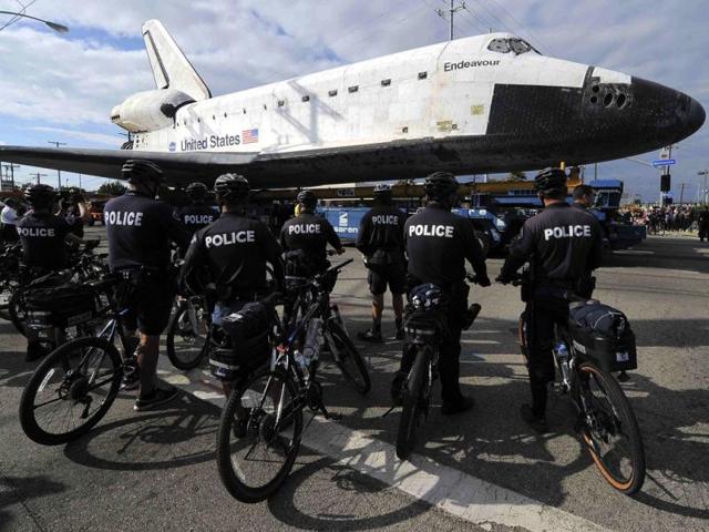 Policemen watch space shuttle Endeavour as it makes its way from Westchester square to Randy's Donuts during its final ground journey in Los Angeles, California. Reuters photo