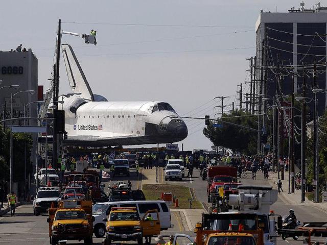The space shuttle Endeavour slowly moves along city streets on a 160-wheeled carrier in Los Angeles. AP Photo