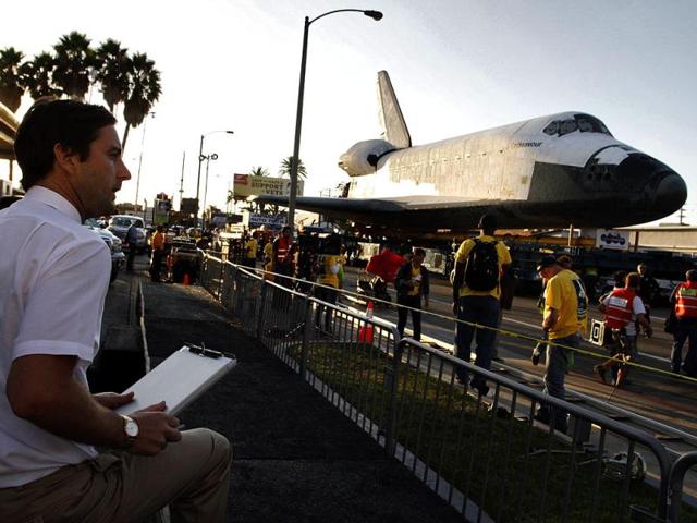 Actor Luke Wilson sits near space shuttle Endeavour on Manchester Avenue while it is being moved from Los Angeles International Airport to its retirement home at the California Science Center in Exposition Park, in Los Angeles. Reuters photo
