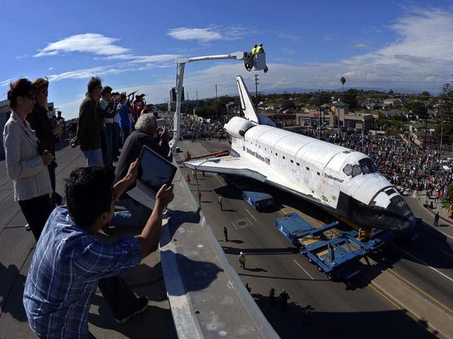 People take pictures from the roof of a building as the space shuttle Endeavour is slowly moved along city streets in Los Angeles. Reuters photo