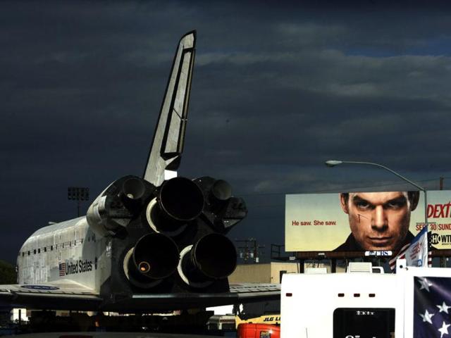 The space shuttle Endeavour makes its way east down Manchester Boulevard under the eyes of a Dexter billboard in Westchester, California. Reuters photo