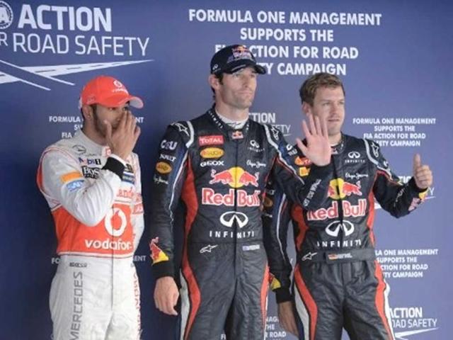 Pole sitter Red Bull-Renault driver Mark Webber of Australia and second-placed Red Bull-Renault driver Sebastian Vettel of Germany wave as third-placed McLaren-Mercedes driver Lewis Hamilton of Britain reacts after the qualifying session of the Formula One Korean Grand Prix in Yeongam. Webber took pole position for the Korean Grand Prix, just ahead of teammate Sebastian Vettel, to ensure a front-row lock-out for Red Bull. AFP / Roslan Rahman