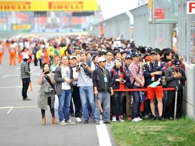Fans wait on the track to get autographs of drivers during an autograph session for the Formula One Korean Grand Prix in Yeongam. AFP / Jung Yeon-Je