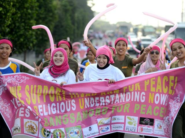 Muslim women hold a banner as they run during an event called HIJAB RUN for Peace: Religious Understanding Now at the People Power Monument in Manila. AFP/Noel Celis