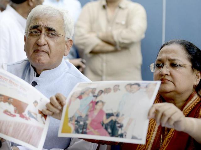 Union minister for Law and justice Salman Khurshid along with his wife Louise Khurshid hold up photographs of a camp for disabled people during a press conference in New Delhi. AFP Photo/Sajjad Hussain