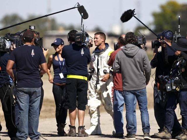 Felix Baumgartner walks with his girlfriend Nici Oetl, facing at left, after Baumgartner successfully jumped from a space capsule in Roswell, New Mexico. AP/Ross D Franklin