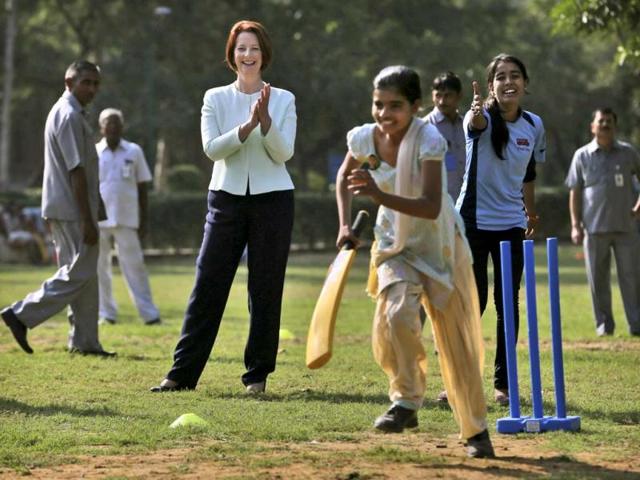Australia's Prime Minister Julia Gillard, center, applauds as she watches girls play cricket at a camp in New Delhi. Gillard is on a three day official visit to India. (AP Photo)