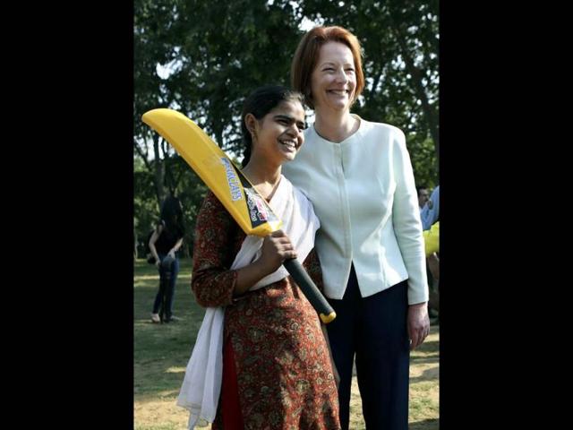 Australia's Prime Minister Julia Gillard, right, poses with a girl during a visit to in New Delhi. Gillard is on a three day official visit to India. (AP Photo)