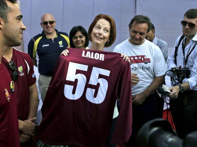 Australia's Prime Minister Julia Gillard, center, holds up a cricket jersey given to her at a camp for underprivileged children in New Delhi. Gillard is on a three day official visit to India. (AP Photo)