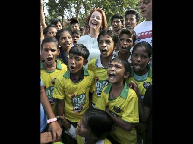 Australia's Prime Minister Julia Gillard, top center, laughs as she poses with underprivileged children at a camp in New Delhi. Gillard is on a three day official visit to India. (AP Photo)