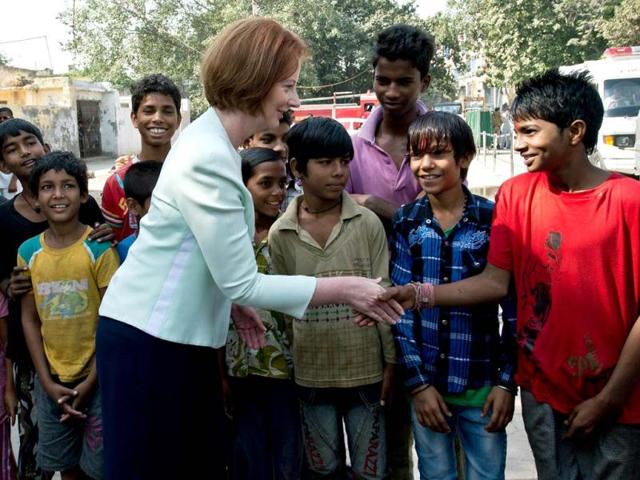 Prime Minister of Australia Julia Gillard (C) shakes hands with slum dwelling children during her visit to Asha Education project site to meet students in New Delhi. Australian Prime Minister is on a three day state visit to India. (AFP Photo)
