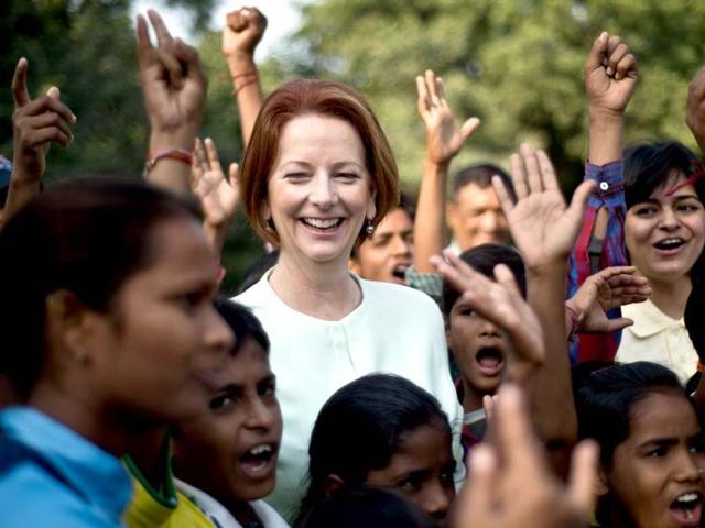 Australian Prime Minister Julia Gillard (C) gestures as she interacts with disadvantaged youth at a cricket clinic in New Delhi. The Australian Prime Minister is on a three-day state visit to India. (AFP Photo)