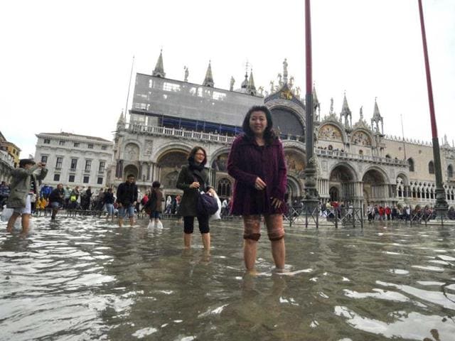 Tourists wade across the flooded St. Mark square as high tides reached 1.05 meters above sea level, partly flooding the city of Venice. AP photo