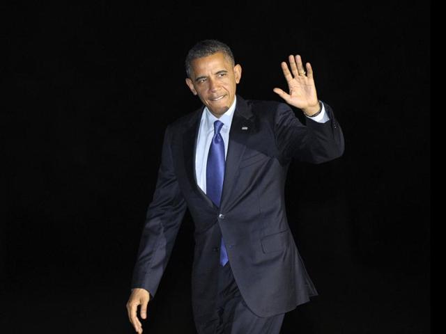 President Barack Obama waves as he returns to the White House in Washington after campaigning in Iowa and Ohio. AP photo