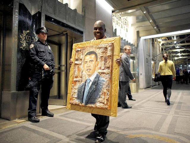A man carries a painting of US President Barack Obama, to be donated to him as a gesture of support for his administration, outside the Waldorf Astoria hotel in New York. Reuters