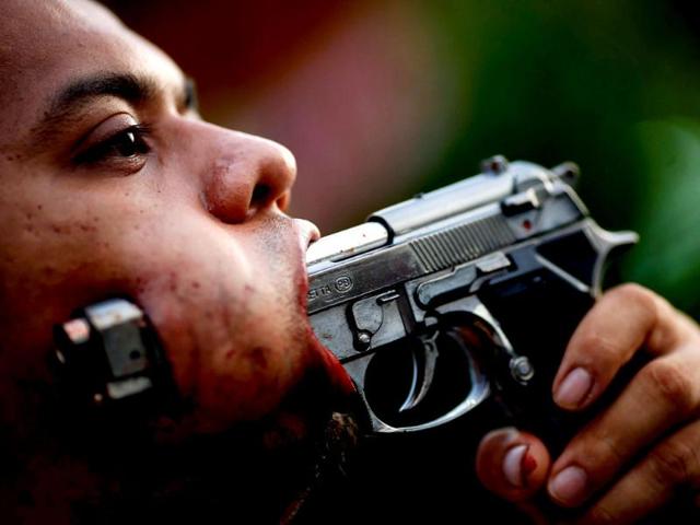 A devotee of Ban Tha Rua Chinese shrine with a gun pierced through his cheek takes a part in a procession celebrating the annual vegetarian festival in Phuket. (Reuters)