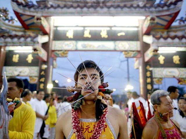 A devotee of Ban Tha Rua Chinese shrine with his cheeks pierced gets ready for a procession celebrating the annual vegetarian festival in Phuket. (Reuters/Damir Sagolj)