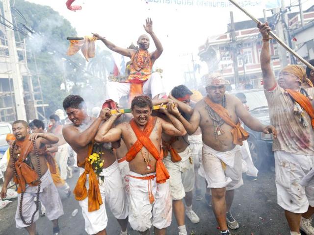 Devotees of Ban Tha Rua Chinese shrine walk through exploding firecrackers during a procession celebrating the annual vegetarian festival in Phuket. (Reuters/Damir Sagolj)