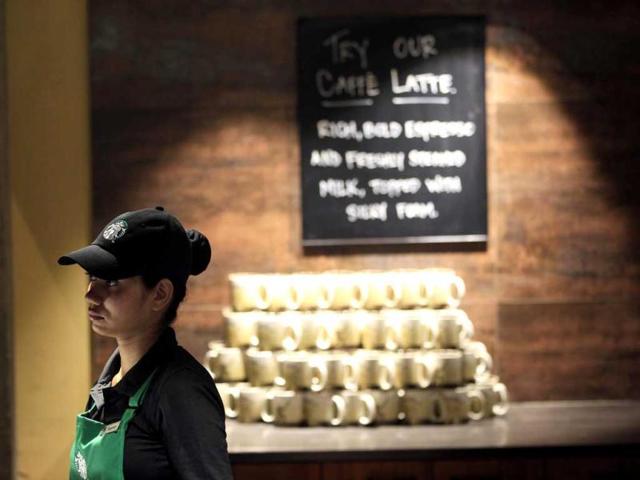 An employee of the newly inaugurated outlet of Starbucks stands at the store in Mumbai. Starbucks inaugurated its first store in India in a building in southern Mumbai as the Seattle-based coffee giant seeks growth in a market long associated with tea drinkers. AP/Rajanish Kakade