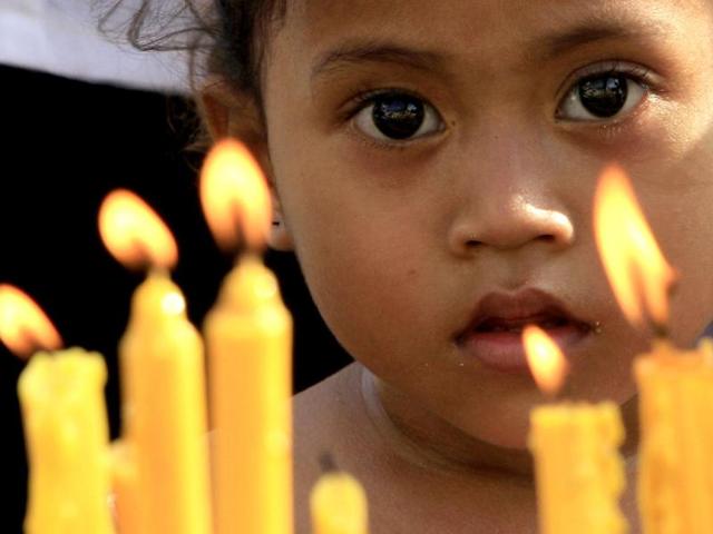 A Cambodian child watches residents offer prayers to the late former King Norodom Sihanouk in front of Royal Palace in Phnom Penh, Cambodia. Hundreds of Cambodian villagers through widely provinces paid their respect and prayed for the soul of their former king on Sunday. AP photo
