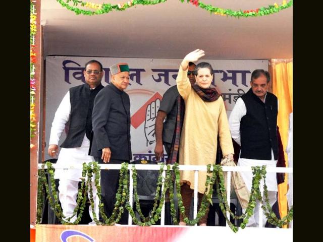 AICC president Sonia Gandhi waves to the crowd as Virbhadhra Singh looks on during a rally in Mandi, Himachal Pradesh. (Agencies)