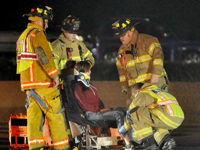 Rescue workers treat a person after they were removed from an airplane that crashed into the eastbound lanes of Interstate 94 north of Highway 11, near Racine Wis. The Skydive Midwest plane slid onto the interstate while attempting to land at the Sturtevant airport. (AP Photo/Journal Times, Gregory Shaver)