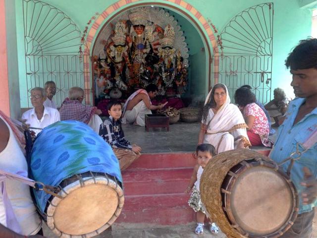 Villagers gather as a Hindu priest perform rituals in front of a clay idol of Goddess Durga for the Durga Puja festival in Hathserandi village, West Bengal. (AFP Photo)