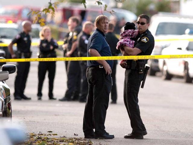 Rancho Cordova Sheriff officer holds a child that was unharmed in the triple homicied on De Soto Way in Rancho Cordova, California. Sacramento County Sheriff's Department officials confirmed that three bodies were found, that of a woman, described as being in her 20s, and her two young children - a girl, 3, and a boy, 2 - dead in one room. A 6-month-old boy was found crying but unharmed in another room. (AP Photo)
