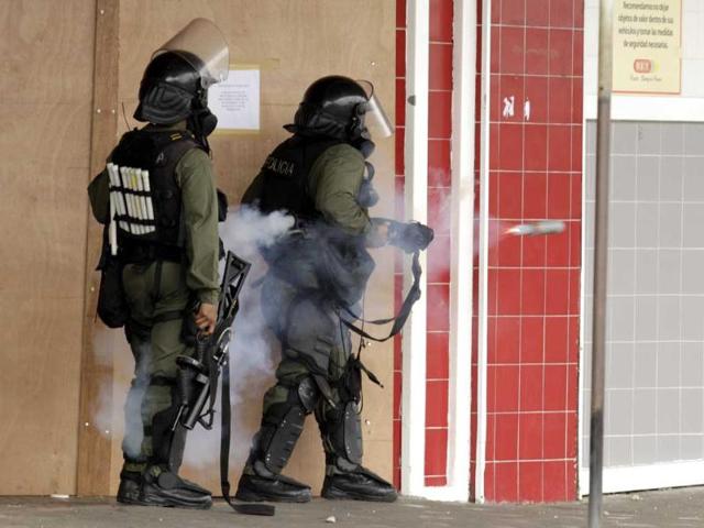 Police officers fire tear gas canisters against demonstratros during a protest in downtown Colon, Panama. Demonstrators protested over a new law allowing the sale of state-owned land in the duty-free zone next to the Panama Canal. AP Photo