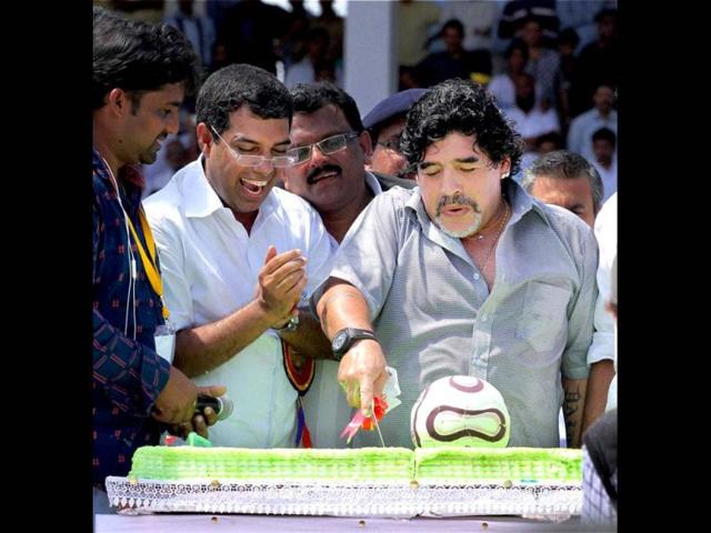 Footballer Diego Armando Maradona cuts a cake to celebrate his 52nd birthday at Jawahar Stadium in Kannur. PTI Photo