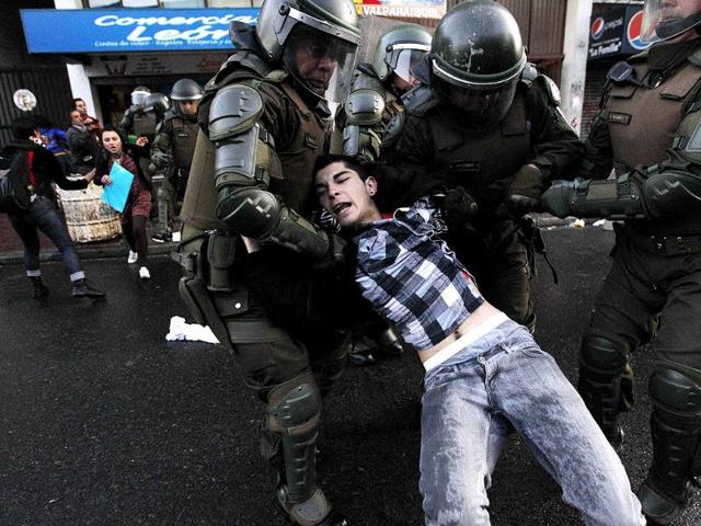 A Mapuche supporter is detained by riot police during a protest against the government in Valparaiso city, about 121 km (75 miles) northwest of Santiago. REUTERS