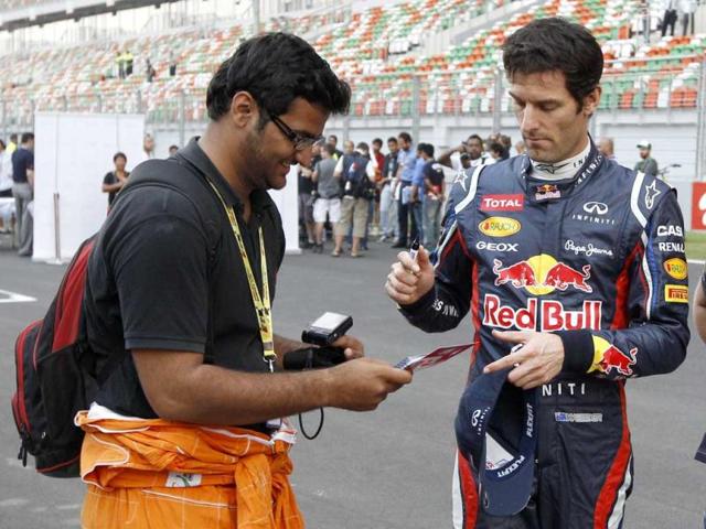 Red Bull driver Mark Webber of Australia signs his autograph for a fan ahead of the Indian Formula One Grand Prix at the Buddh International Circuit in Greater Noida. AP Photo