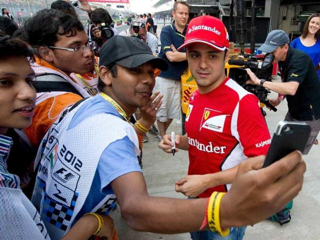 Ferrari driver Felipe Massa (R) of Brazil has his picture taken with fans at The Buddh International circuit in Greater Noida. AFP Photo