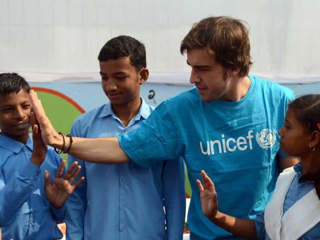 Ferrari driver Fernando Alonso (2R) of Spain interacts with Indian children during an event organised by UNICEF to promote 'hand-washing' at a school in Greater Noida. AFP Photo