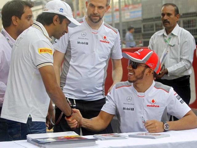 McLaren Formula One driver Lewis Hamilton of Britain (R) shakes hands with HRT Formula One driver Narain Karthikeyan of India at the Buddh International Circuit in Greater Noida, on the outskirts of Delhi. Reuters Photo