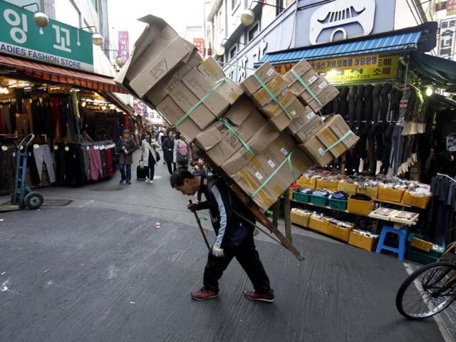 A worker carries stacks of boxes on his back at the Namdaemun Market in Seoul. South Korea's economy grew by 0.2 percent in the July-September period from the previous three-month period, the slowest quarterly growth since the fourth quarter of 2009 in Asia's fourth-largest economy. The median forecast called for a 0.1 percent expansion. REUTERS