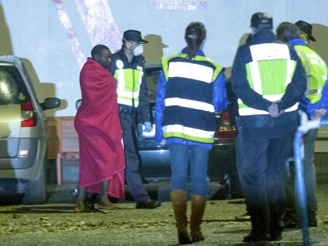 A member of the Spanish police escorts a would-be immigrant after his arrival at the southern Spanish port of Motril. The bodies of some 14 would-be immigrants and 17 survivors, made up of 14 men and 3 women, were found floating as well as intercepted aboard a semi-sunken boat, off the Moroccan coast as they were heading to European soil from Africa, authorities said. REUTERS