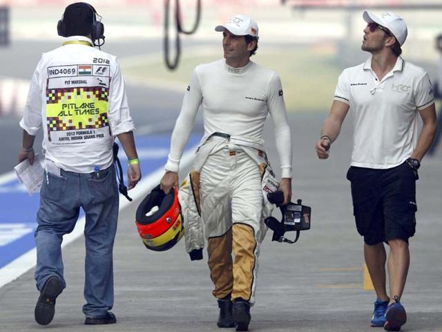 HRT Formula One driver Pedro de la Rosa (C) of Spain walks in the pit lane before the first practice session of the Indian F1 Grand Prix at the Buddh International Circuit in Greater Noida, on the outskirts of New Delhi. REUTERS/Vivek Prakash