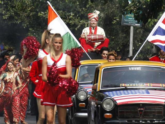 Virgin Group’s Sir Richard Branson sitting on top of a black-and-yellow city taxi, plays a traditional drum during a photo opportunity parade in Nariman point. Branson is in the city to announce the launch of Virgin Atlantic's new service from Mumbai to London. HT Photo/Vijayanand Gupta