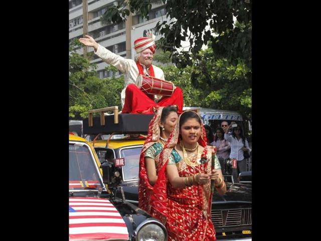 Virgin Group’s Sir Richard Branson sitting on top of a black-and-yellow city taxi, plays a traditional drum during a photo opportunity parade in Nariman point. Branson is in the city to announce the launch of Virgin Atlantic's new service from Mumbai to London. HT Photo/Vijayanand Gupta