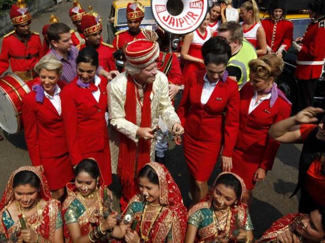 Virgin Group’s Sir Richard Branson sitting on top of a black-and-yellow city taxi, plays a traditional drum during a photo opportunity parade in Nariman point. Branson is in the city to announce the launch of Virgin Atlantic's new service from Mumbai to London. HT Photo/Vijayanand Gupta