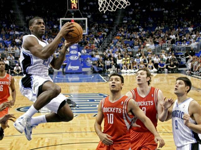Orlando Magic's DeQuan Jones, left, goes in for a shot past Houston Rockets' Carlos Delfino (10), of Argentina, and Omer Asik (3), of Turkey, as Nikola Vucevic (9), of Montenegro, watches during the first half of an NBA preseason basketball game in Orlando. (AP Photo)