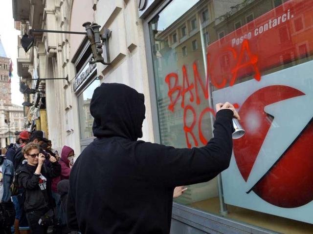 Demonstrators paint 'broken bank' on the shop window of a Unicredit bank during the No Monti Day demonstration in Rome. AFP photo