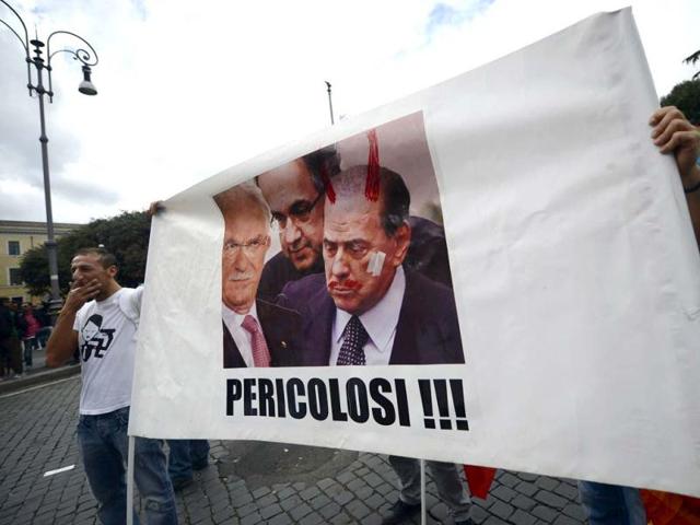 Demonstrators hold a placard showing former Italian Prime Minister Silvio Berlusconi and reading "Dangerous!!!" during the No Monti Day demonstration in Rome. AFP photo