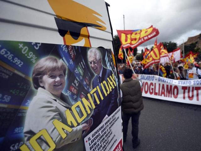 A banner showing Italian Prime Minister Mario Monti and German Chancellor Angela Merkel is displayed at the start of the No Monti Day demonstration in Rome. AFP photo